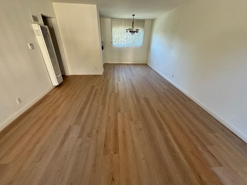 a renovated living room with hardwood flooring and white walls